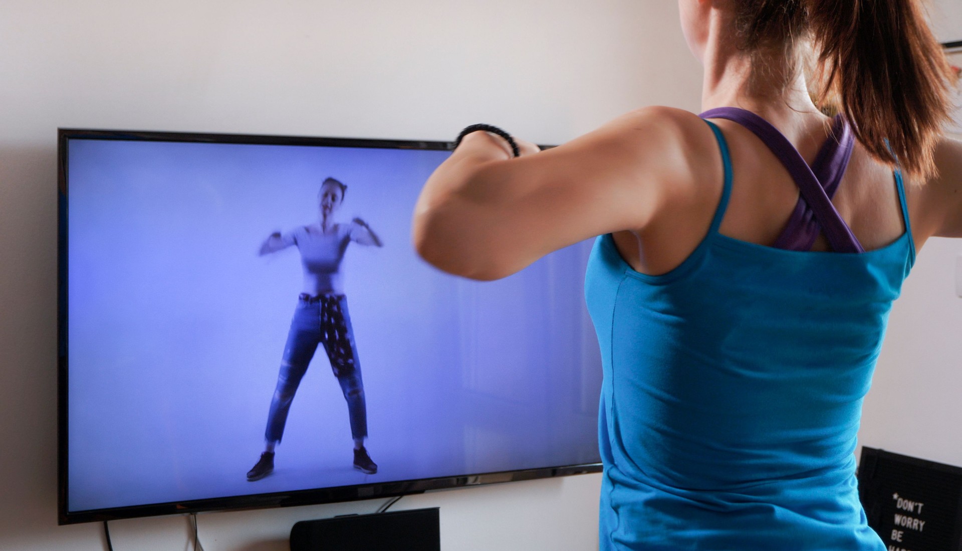 Woman doing workout in front of tv screen